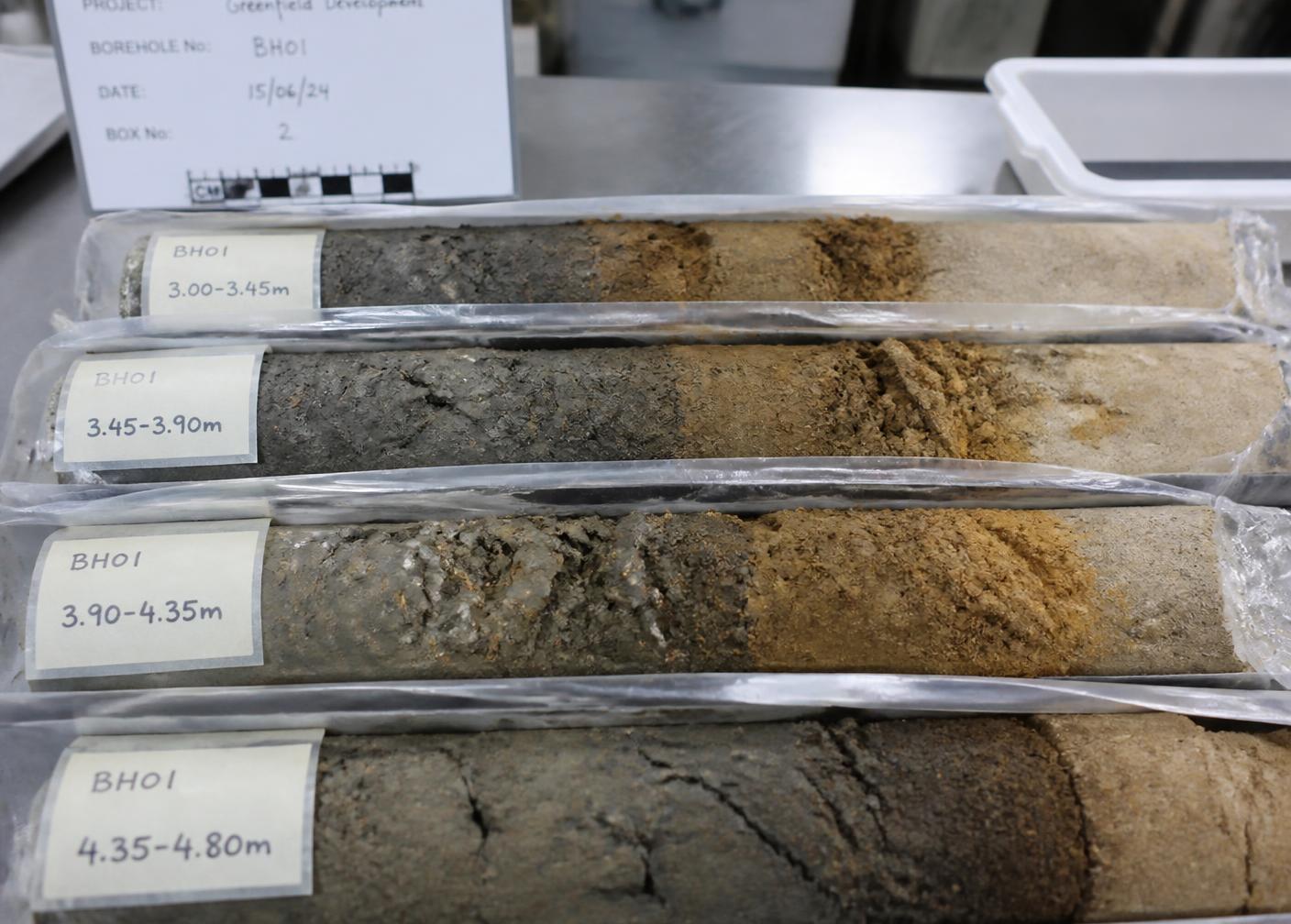 Labeled soil core samples from a borehole laid out for logging in the materials laboratory